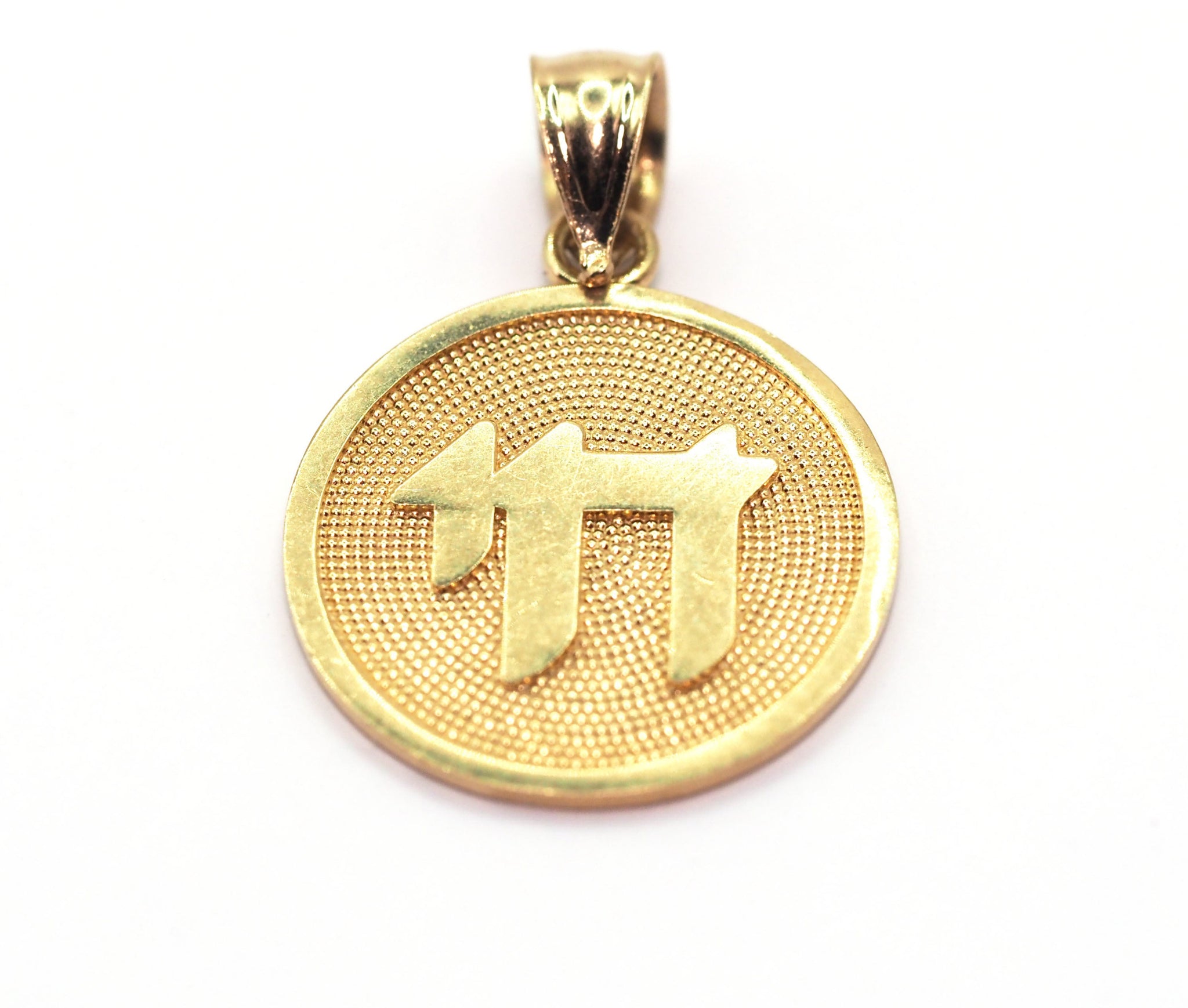 Gold pendant with a textured design on a white background